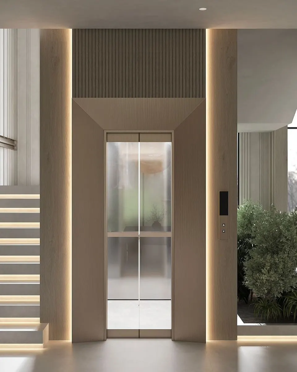 Frosted glass lift doors framed by warm wood panels and vertical lighting beside a staircase